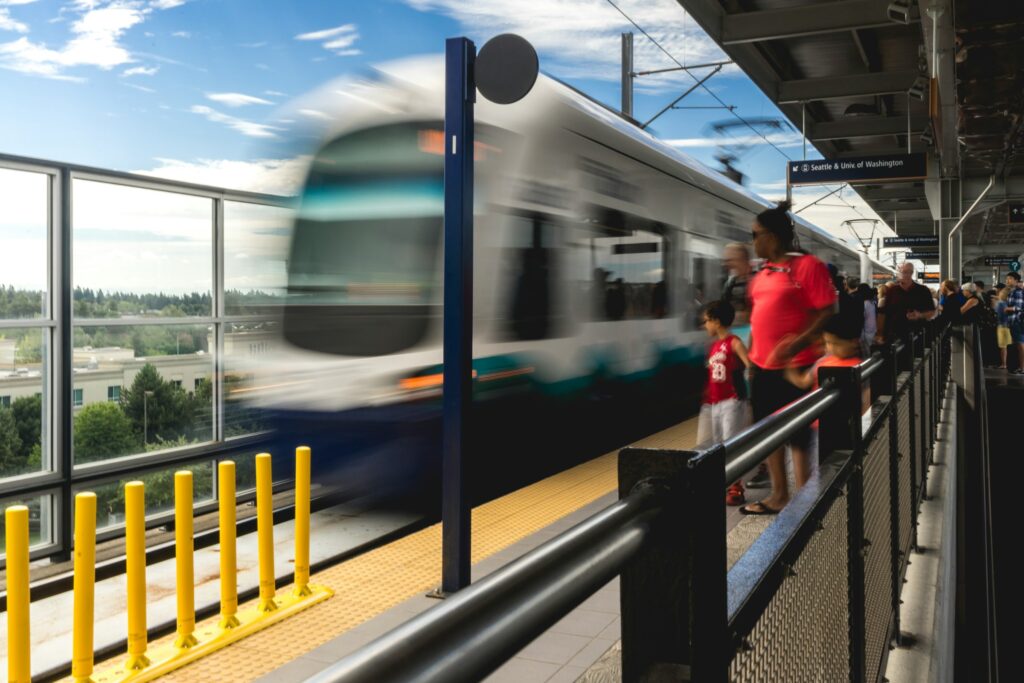 People waiting for a light rail train arriving at a station